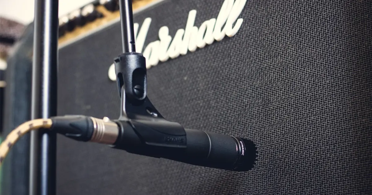 Mini pied de micro en location chez Clem Events supportant un micro SM57 devant un amplificateur de guitare