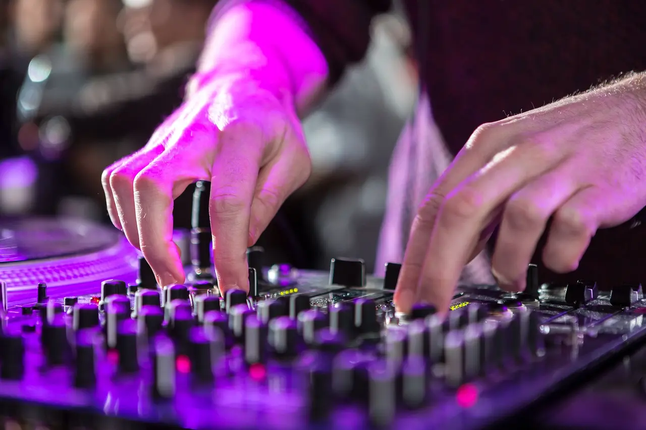 table de mixage et main du Dj en couleur avec des projecteurs led